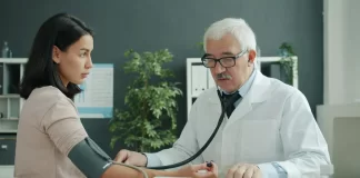Lekarz mierzy ciśnienie młodej kobiecie w nowoczesnym gabinecie.